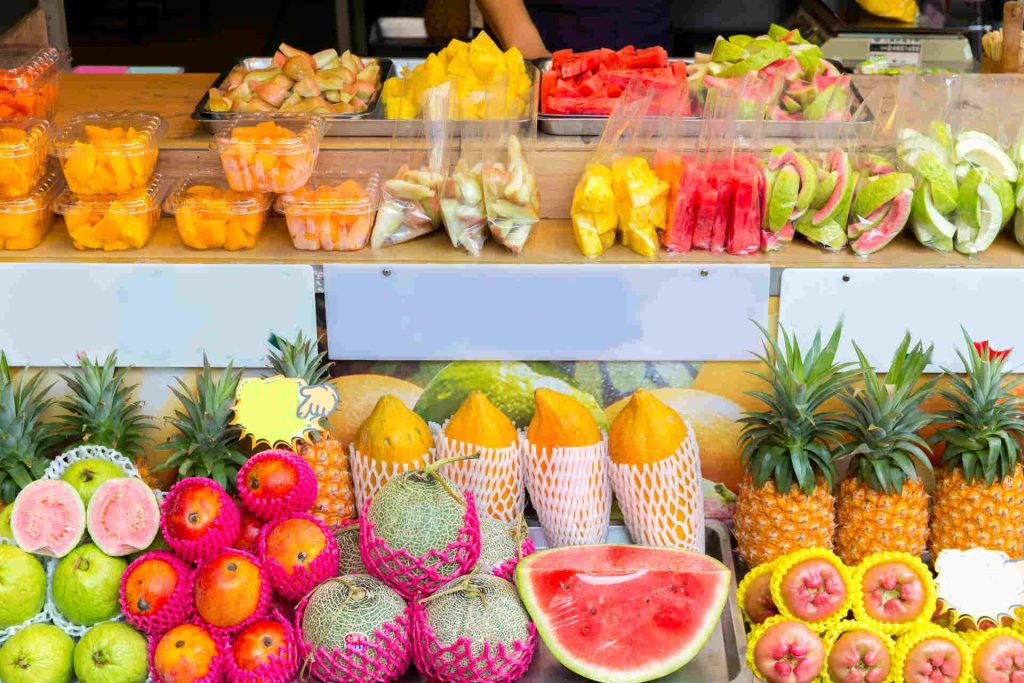 A grocery store filled with a variety of tropical fruits and vegetables