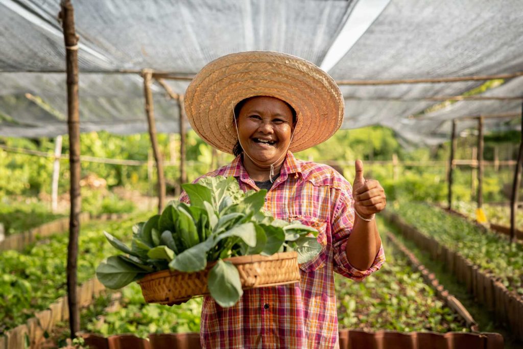 A Thai farmworker with harvested vegetables